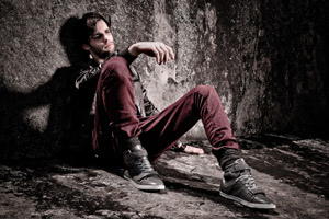 Alex Lago - model - Alex leaning against a dark stone wall